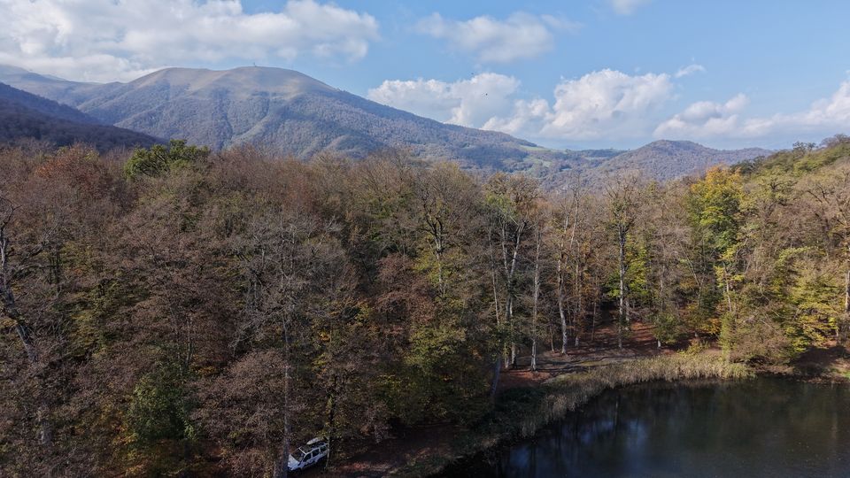 Autumn forest and a dark lake seen from a drone at Gosh Lake