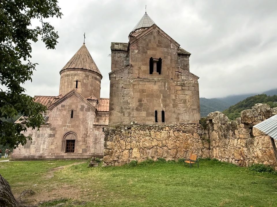Goshavank Monastery buildings of pale stone on a green lawn